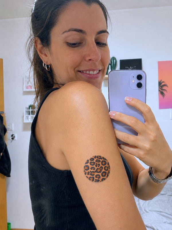 Clienta con un parche Patch Me Up de estampado leopardo sobre su sensor en el brazo